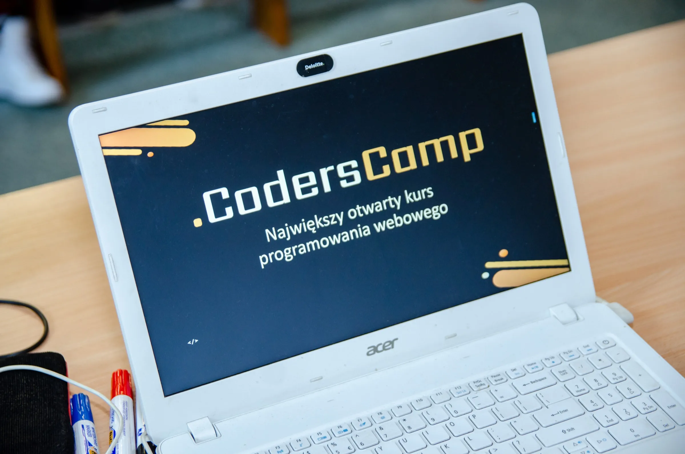 Laptop z ekranem powitalnym kursu CodersCamp — największego otwartego kursu programowania webowego